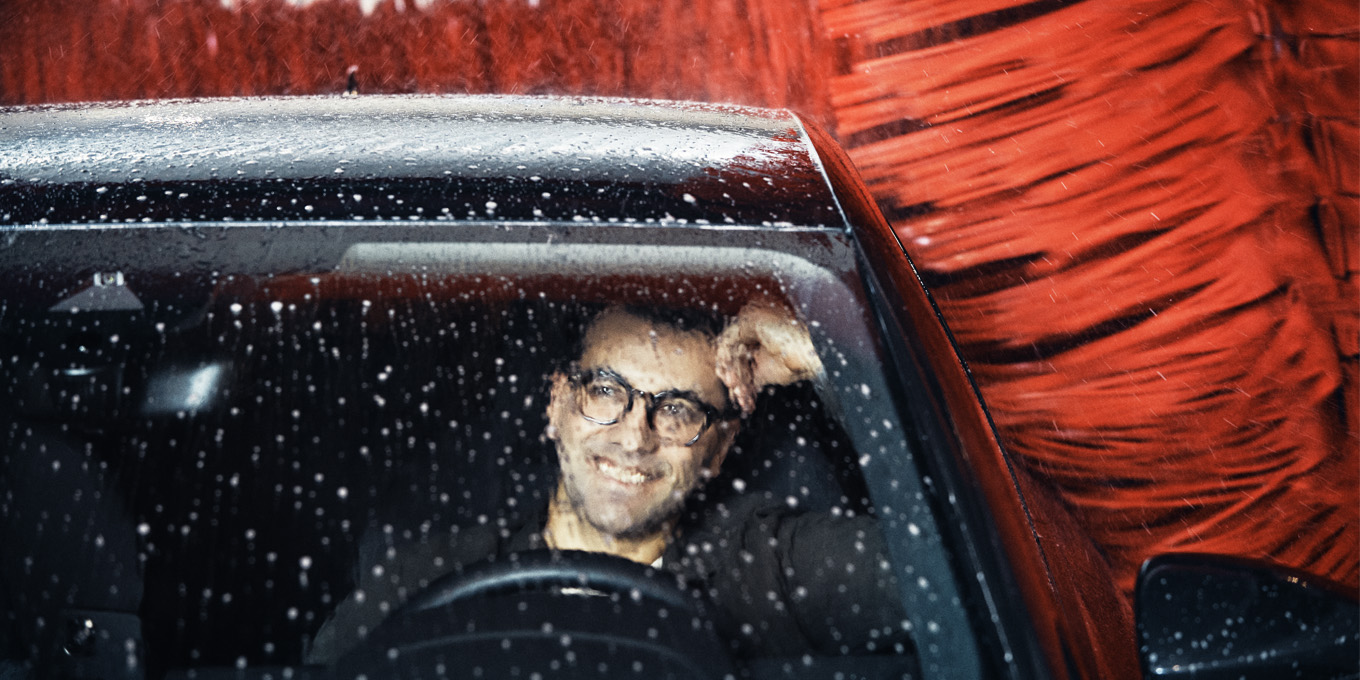 Mand sidder i bilen, mens den vaskes i vaskehal