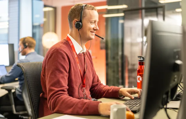 Man helping customers on the phone in a Circle K office