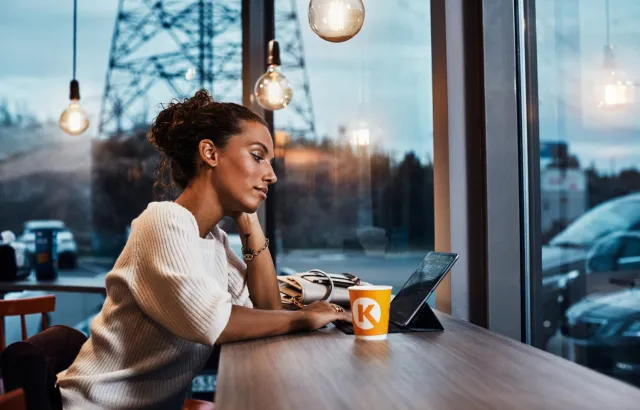 Woman using her tablet in a Circle K café, with a coffee